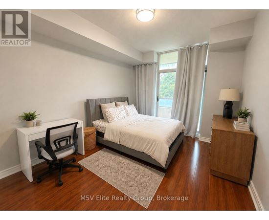 A bedroom with a bed, desk, and chair.