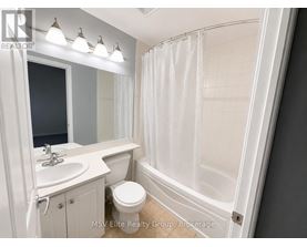 A white bathroom with a toilet, sink, and shower.