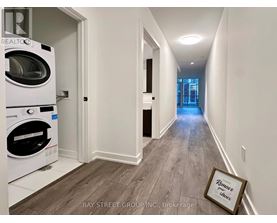 A hallway with a washing machine in the corner and a picture frame on the floor.