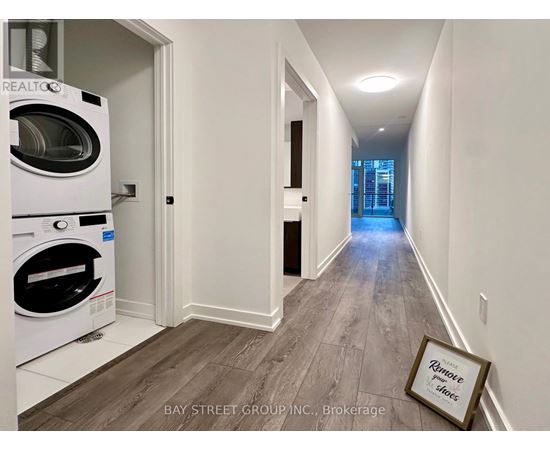 A hallway with a washing machine in the corner and a picture frame on the floor.