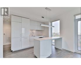 A white kitchen with a large island and a window.
