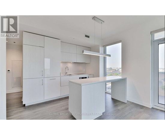 A white kitchen with a large island and a window.