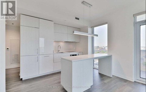 A white kitchen with a large island and a window.