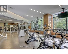 A gym with a variety of exercise equipment including treadmills, stationary bikes, and weight machines.