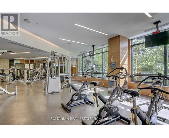 A gym with a variety of exercise equipment including treadmills, stationary bikes, and weight machines.
