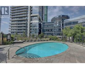 A swimming pool in a backyard with a building in the background.
