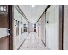 A hallway with doors on both sides and a sign that says "REALTOR" on the wall.