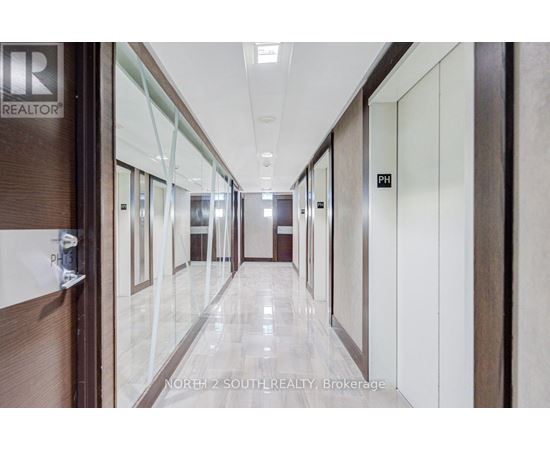 A hallway with doors on both sides and a sign that says "REALTOR" on the wall.