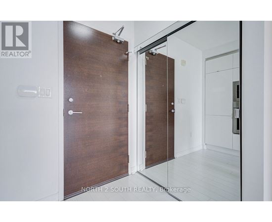 A modern room with a wooden door and a glass door.