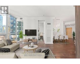 A modern living room with a flat screen TV, a sofa, a coffee table, and a dining table with chairs.