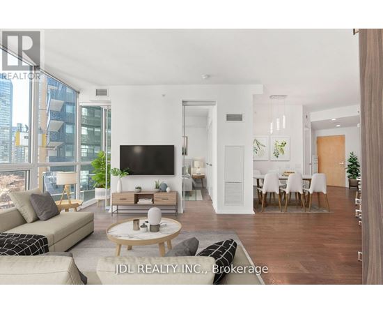 A modern living room with a flat screen TV, a sofa, a coffee table, and a dining table with chairs.