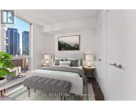 A bedroom with a large bed and a city view through the window.
