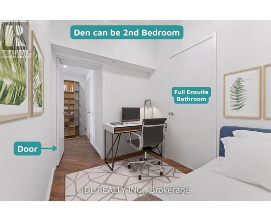 A bedroom with a desk and a full bathroom in the other room.