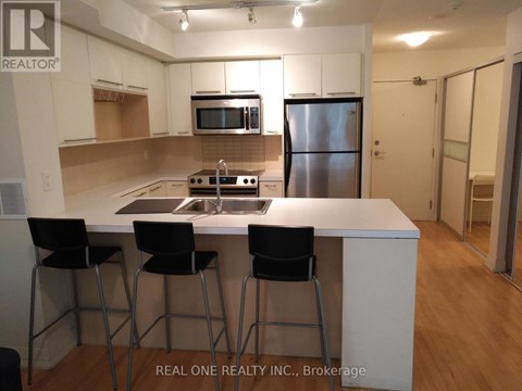 A kitchen with white cabinets and a stainless steel refrigerator.