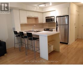 A kitchen with a white table and black chairs.