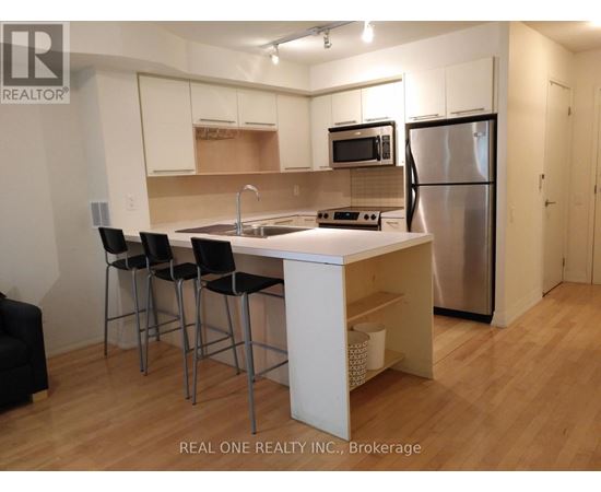 A kitchen with a white table and black chairs.