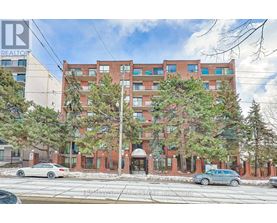 A large red brick building with trees in front of it.