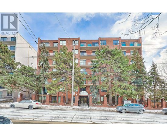 A large red brick building with trees in front of it.