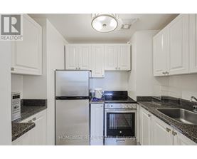 A kitchen with white cabinets and a black stove top.