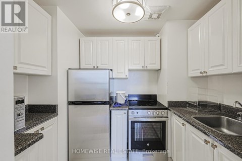 A kitchen with white cabinets and a black stove top.