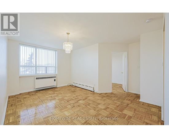 A room with a wooden floor and a window with blinds.