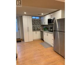 A kitchen with a refrigerator, cabinets, and a countertop.