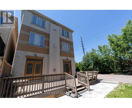 A two-story residential building with a balcony and a small garden.