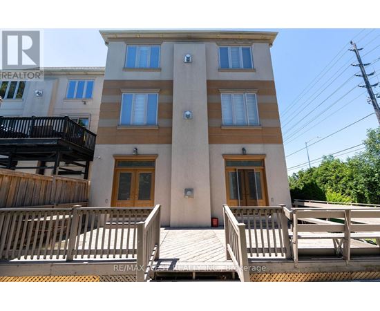 A two-story building with a balcony and a deck in front.