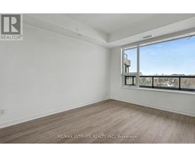 A room with a large window and a view of buildings outside.