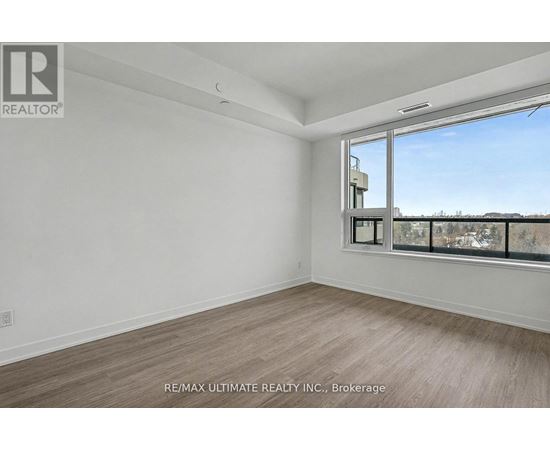 A room with a large window and a view of buildings outside.