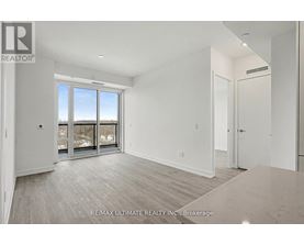 A spacious room with a large window and sliding glass doors.