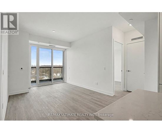 A spacious room with a large window and sliding glass doors.