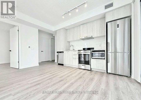 A modern kitchen with white cabinets and stainless steel appliances.