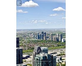 A cityscape with a mix of modern and older buildings under a clear sky.