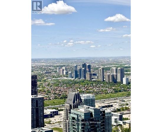 A cityscape with a mix of modern and older buildings under a clear sky.