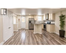 A kitchen with wooden floors and white walls.