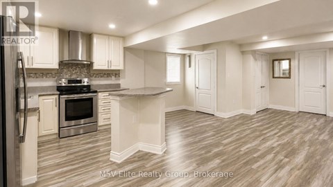 A modern kitchen with a stainless steel refrigerator and a center island.