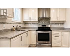 A kitchen with a stove top oven and a sink.