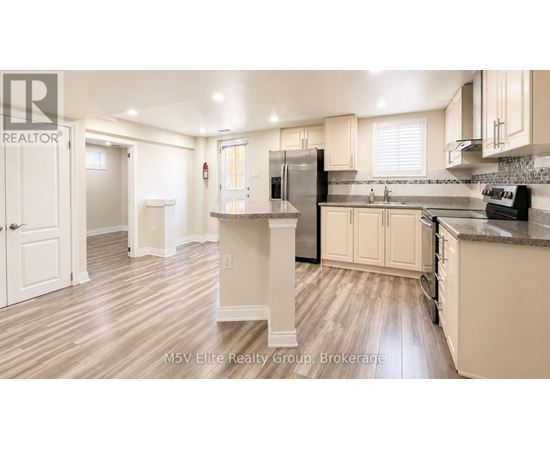 A kitchen with white cabinets and a black refrigerator.