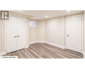 A bedroom with a white door and a white wall.