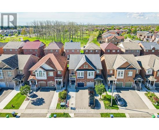 A bird's eye view of a residential area with houses and parked cars.
