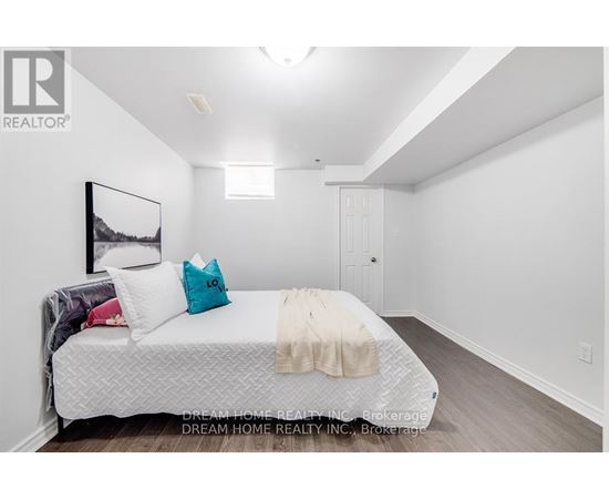 A bedroom with a bed, pillows, and a blanket.