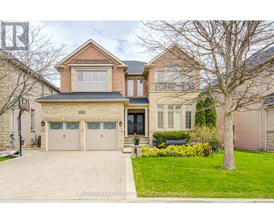 A large, well-maintained house with a brick facade and a large driveway.