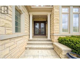 A house entrance with a glass door and steps leading up to it.