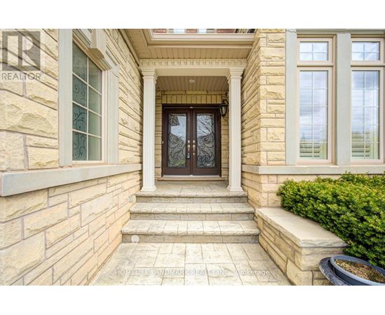 A house entrance with a glass door and steps leading up to it.