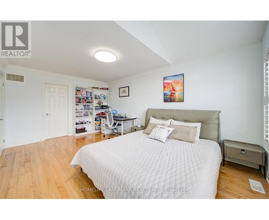 A bedroom with a large bed and a bookshelf filled with books.