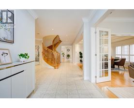 A spacious living room with a wooden spiral staircase.