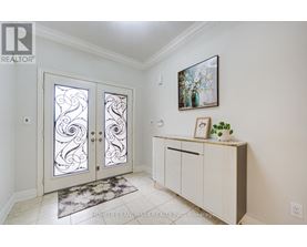 A white interior with a glass door and a framed picture on the wall.