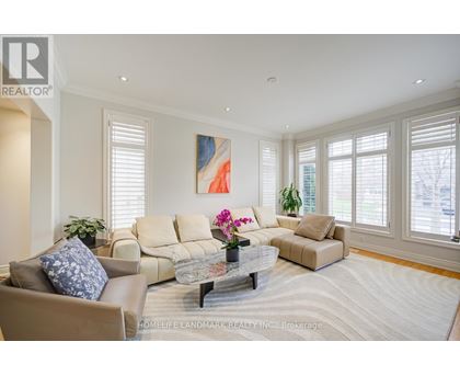 A living room with a beige couch, a coffee table, and a painting on the wall.
