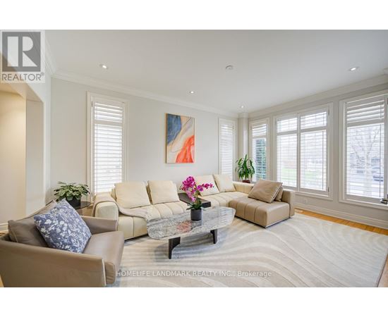 A living room with a beige couch, a coffee table, and a painting on the wall.